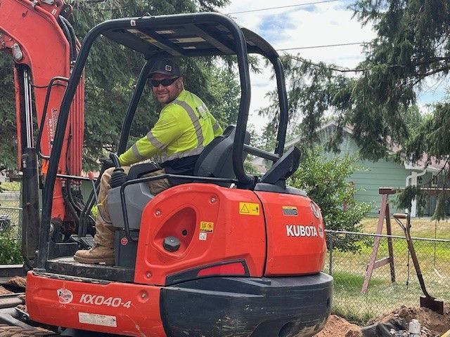 Man is Sitting on a Red Excavator — North Branch, MN — Hassle Free Septic a man is sitting on a red kubota excavator — North Branch, MN — Hassle Free Septic