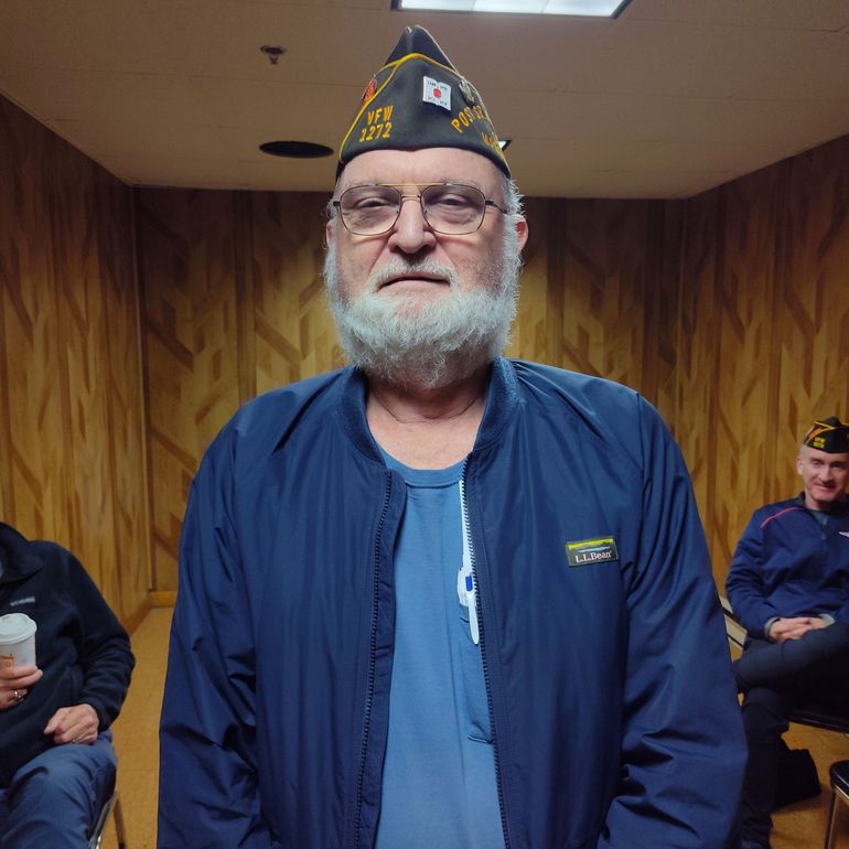 A man with a beard wearing a military hat