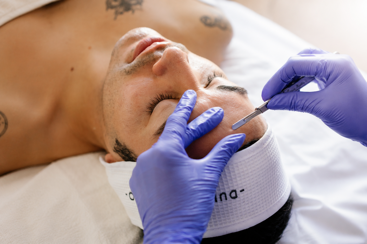 A woman is laying in a bed with red lights on her face.