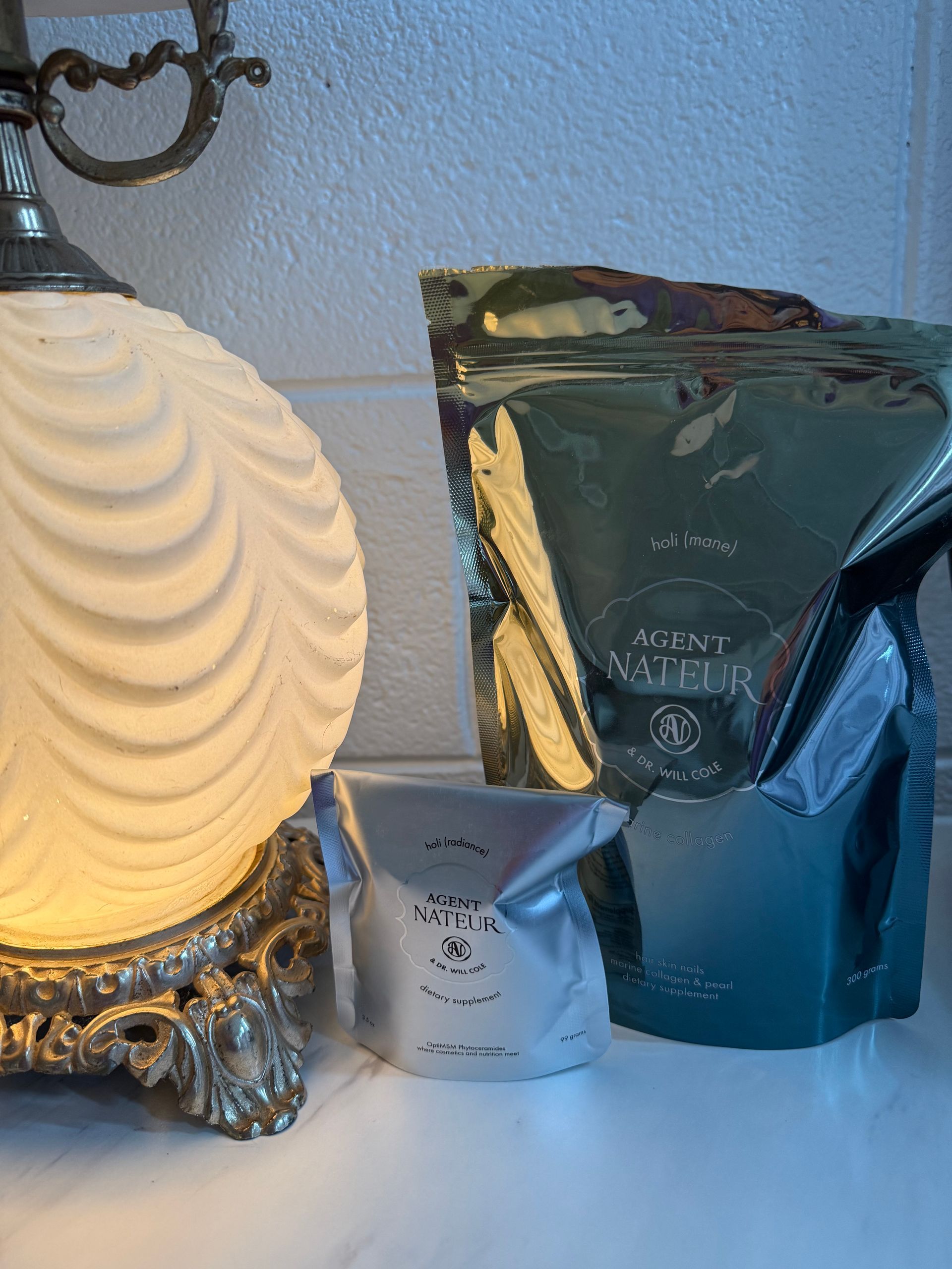 Decorative lamp beside three metallic coffee bags on a table