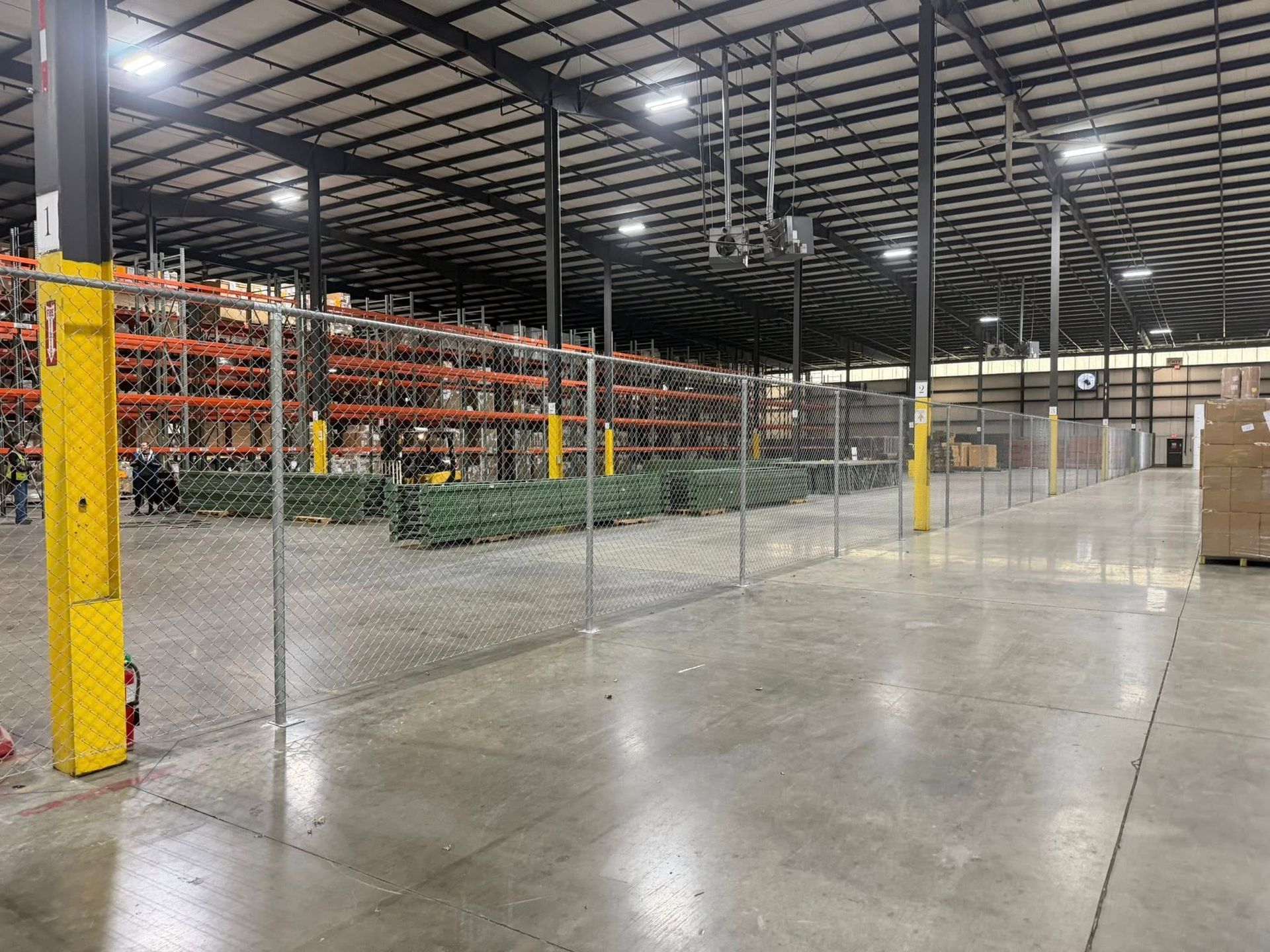 Empty warehouse interior with metal racks, concrete floor, and yellow support columns
