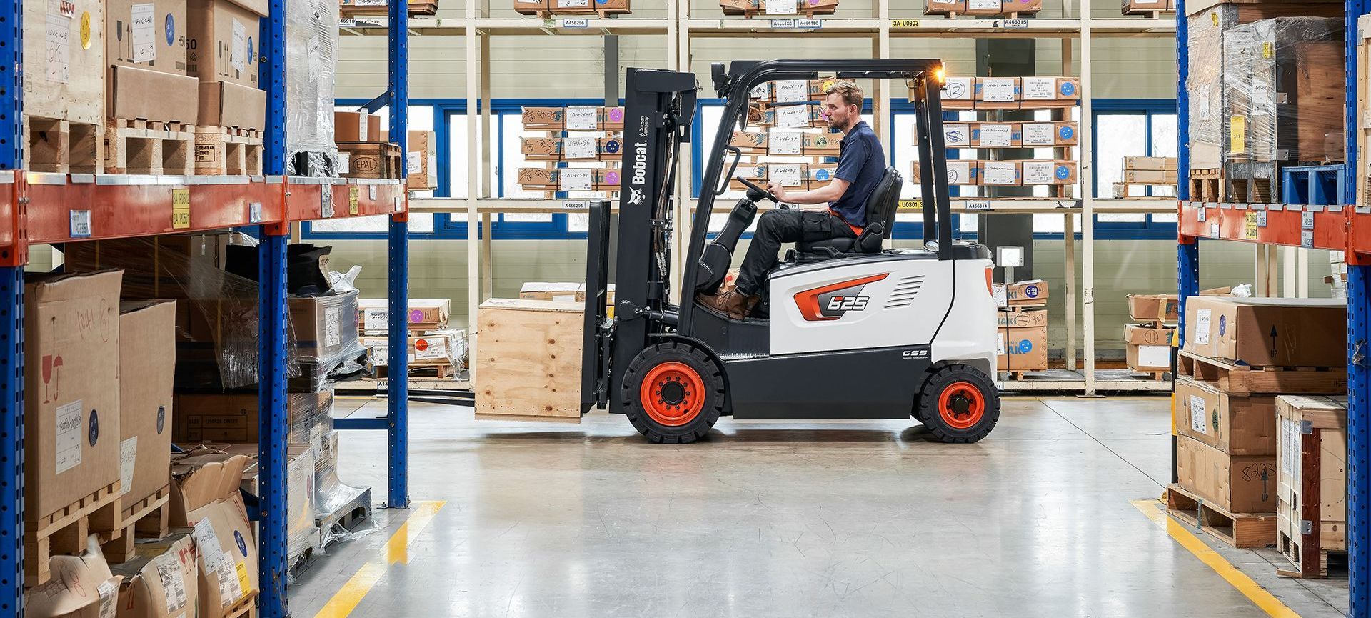 A man is driving a forklift in a warehouse.