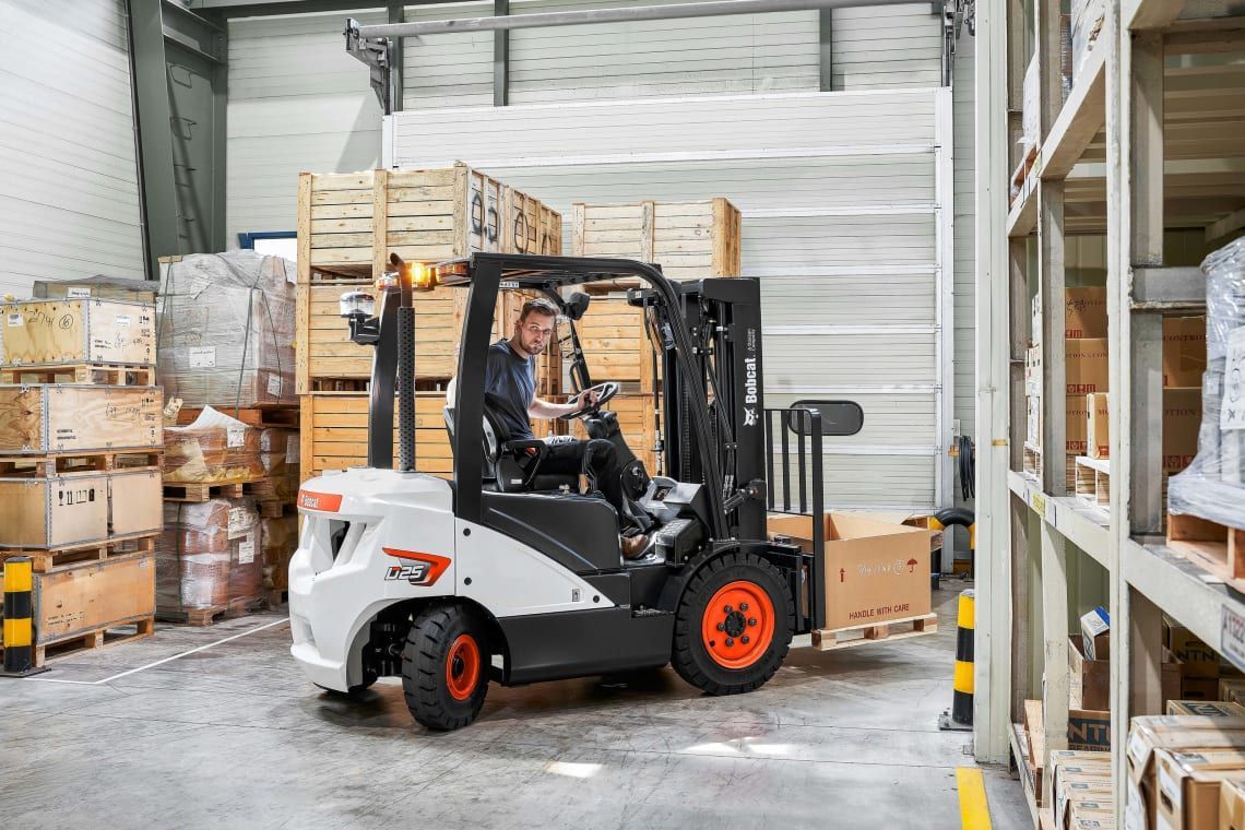 A man is driving a forklift in a warehouse.