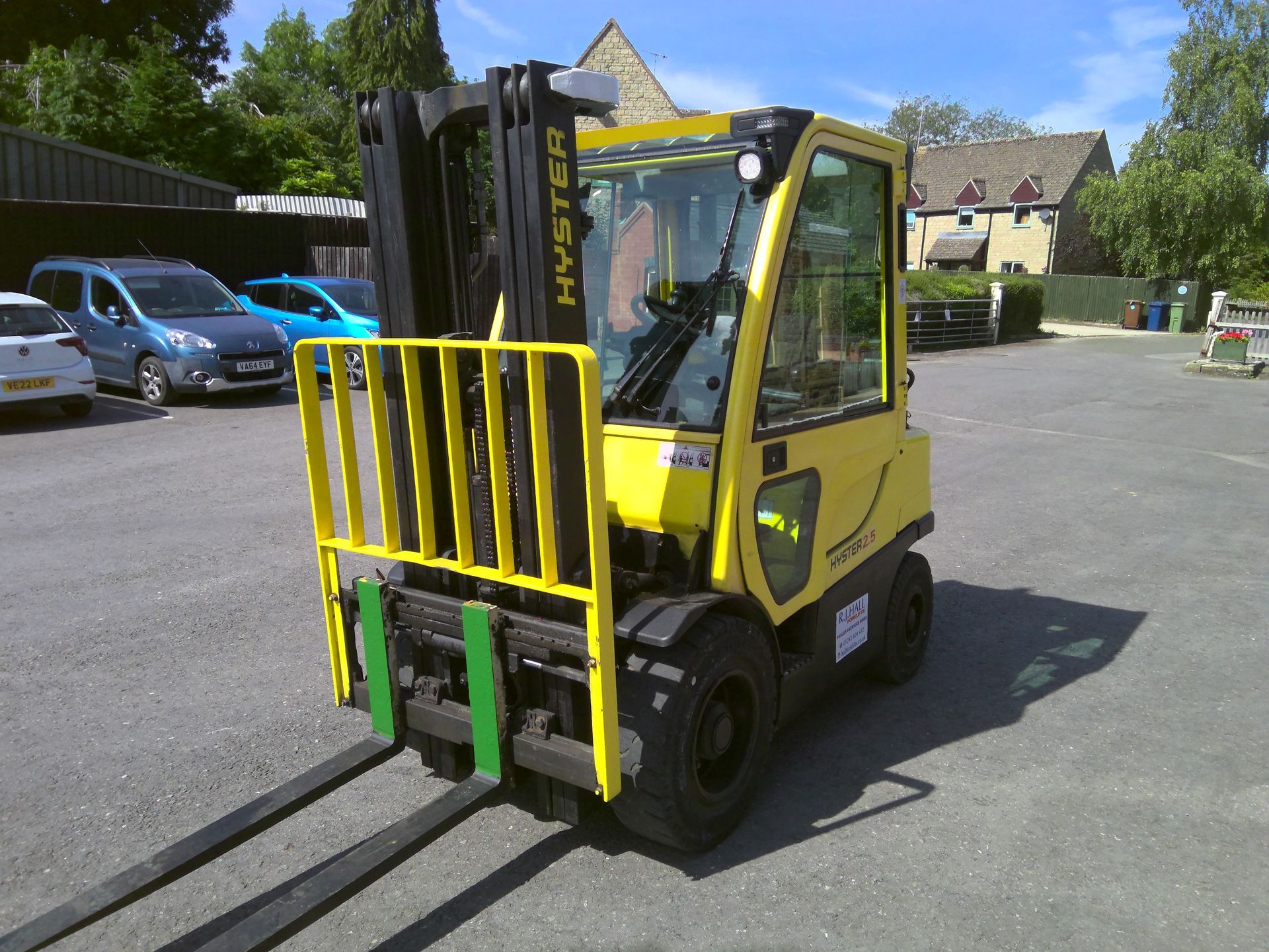 A yellow hyster forklift is parked in a parking lot