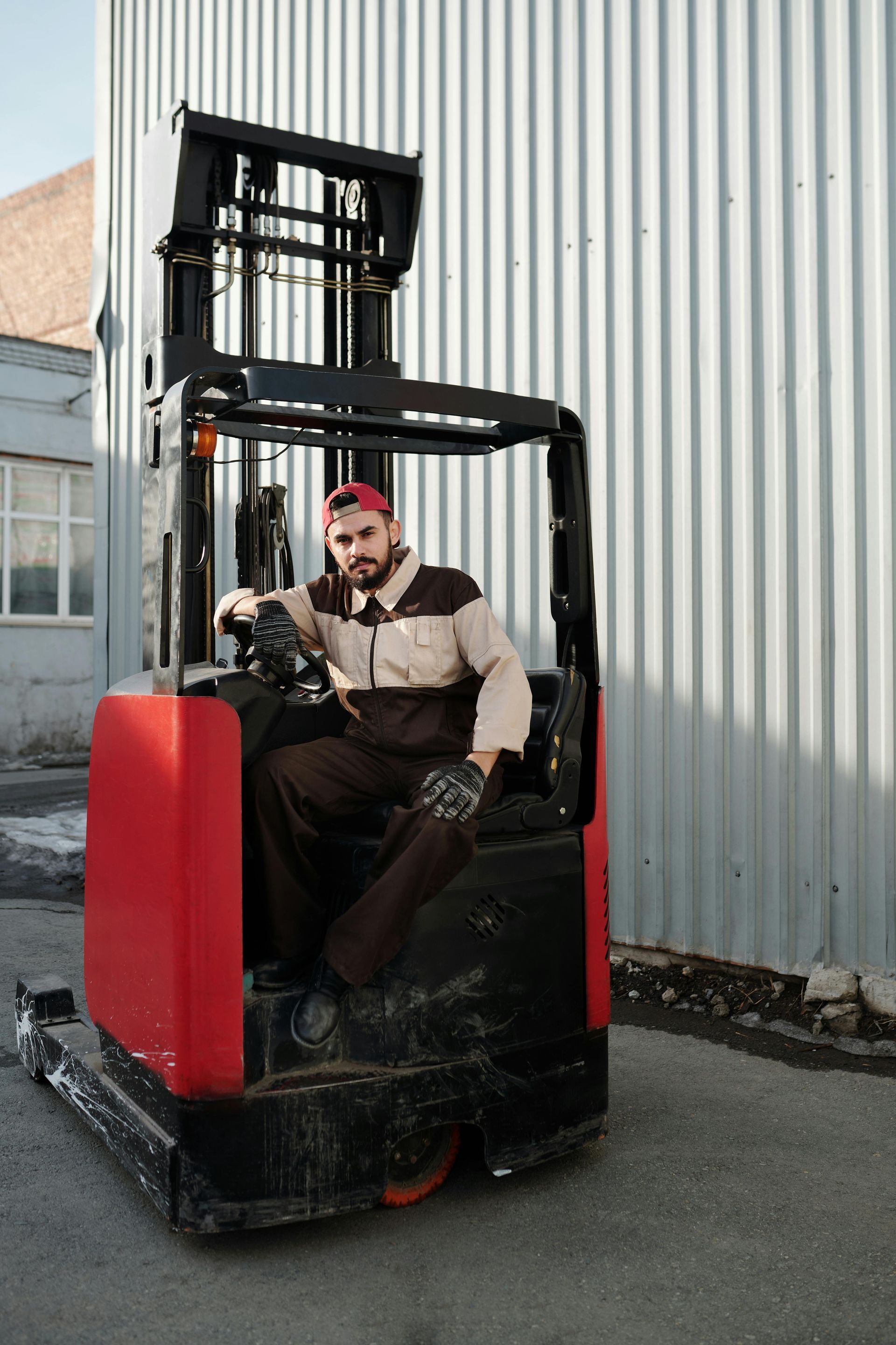 Certified technician performing a forklift safety inspection in a UK warehouse, checking hydraulic and brake systems to ensure compliance and performance