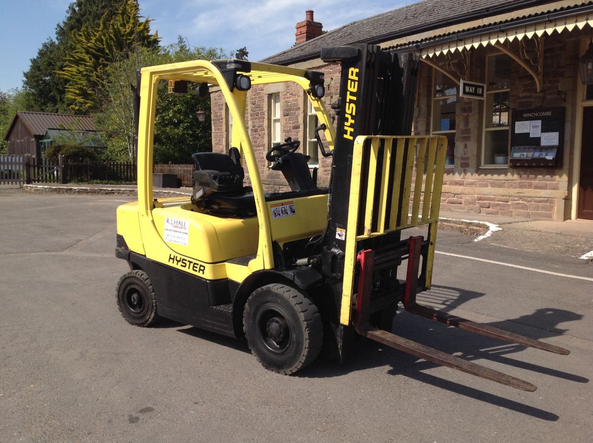 A yellow hyster forklift is parked in a parking lot