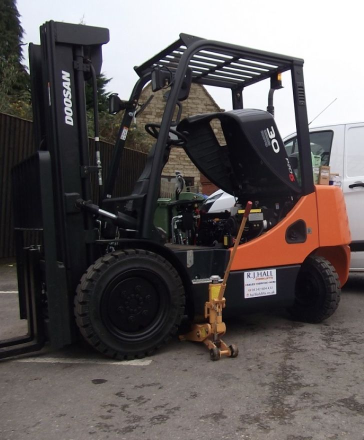 A doosan forklift is parked in a parking lot