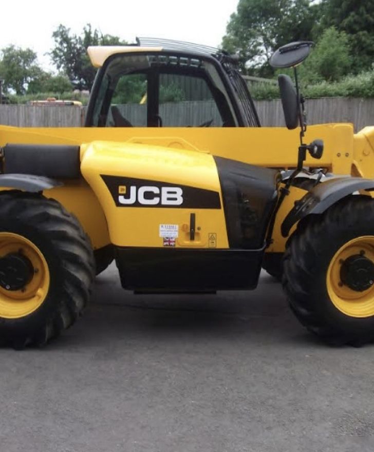 A yellow jcb truck is parked on the side of the road