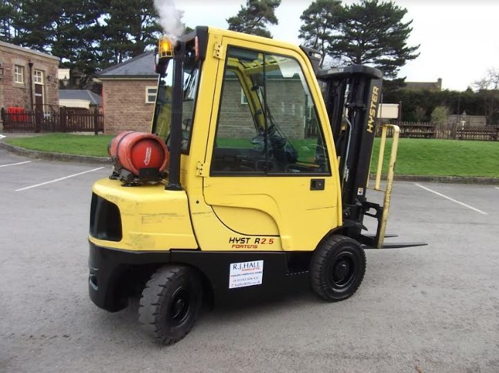 A yellow forklift is parked in a parking lot