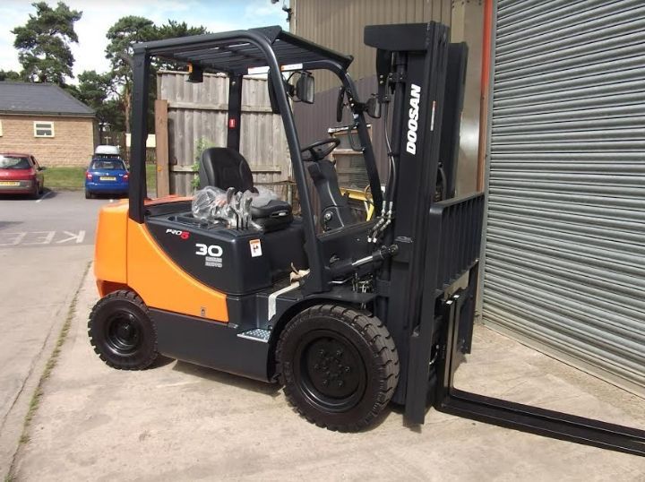 A doosan forklift is parked in front of a building
