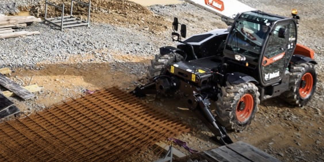 A bulldozer is driving down a dirt road on a construction site.