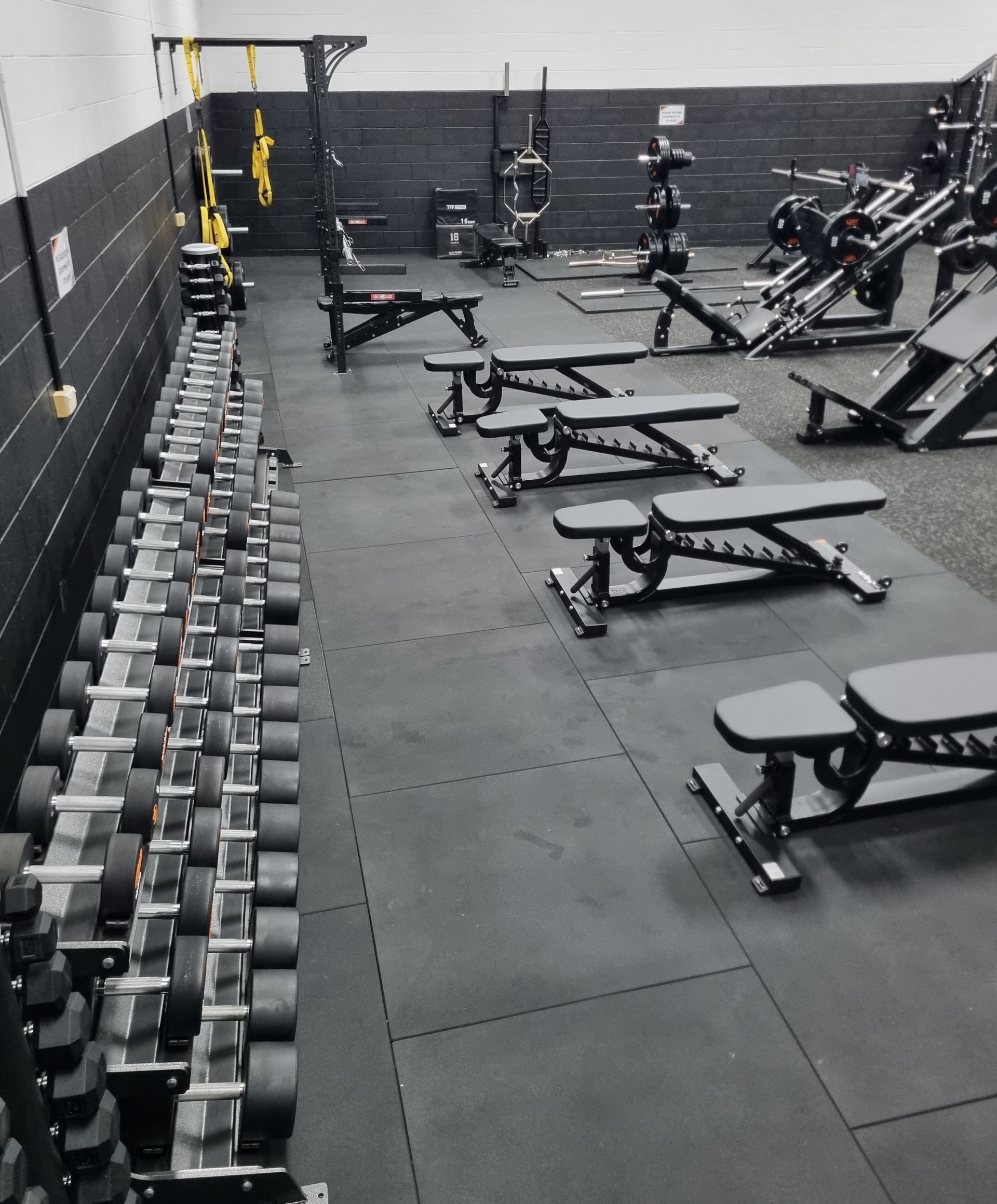 Black Weight Bench With Attached Barbell Rests in a Gym — Ultimate Results Training in Aitkenvale, QLD