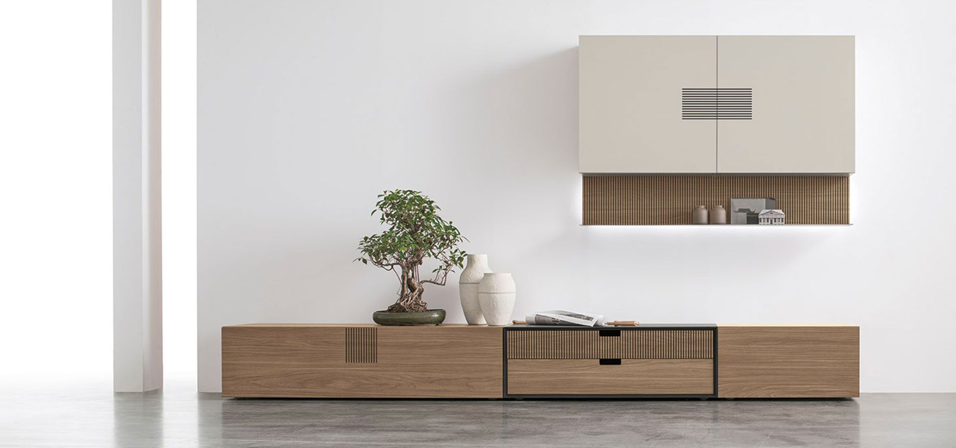 Un soggiorno con un mobile porta TV in legno e una parete bianca.