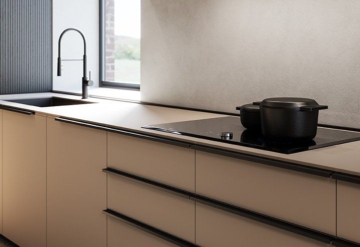 Una cucina con una pentola sul fornello e un lavandino.