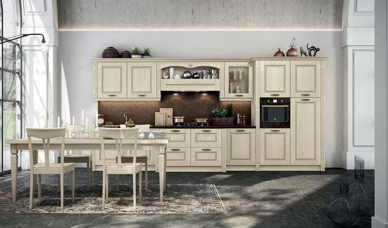 Una cucina con mobili bianchi, tavolo da pranzo e sedie