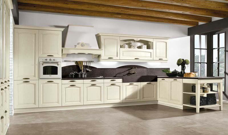 Una cucina con mobili bianchi e soffitto in legno