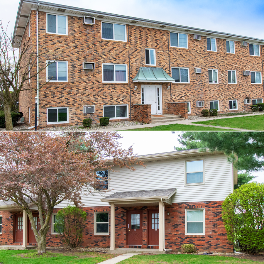Two-story brick apartment building with white windows and doors, green lawn. Two-story brick and white-sided apartment building with two front doors and a small walkway.