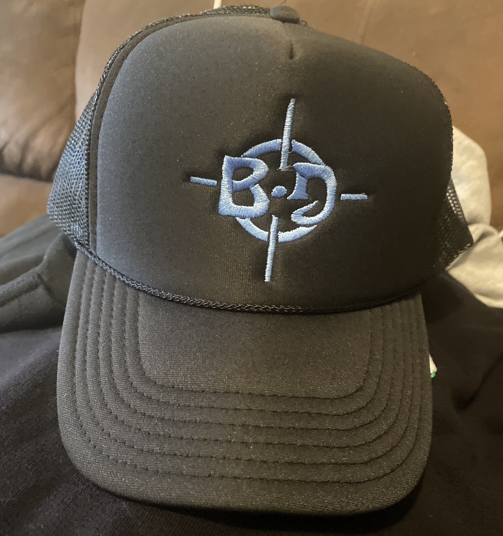 A black trucker hat with the letter b on it