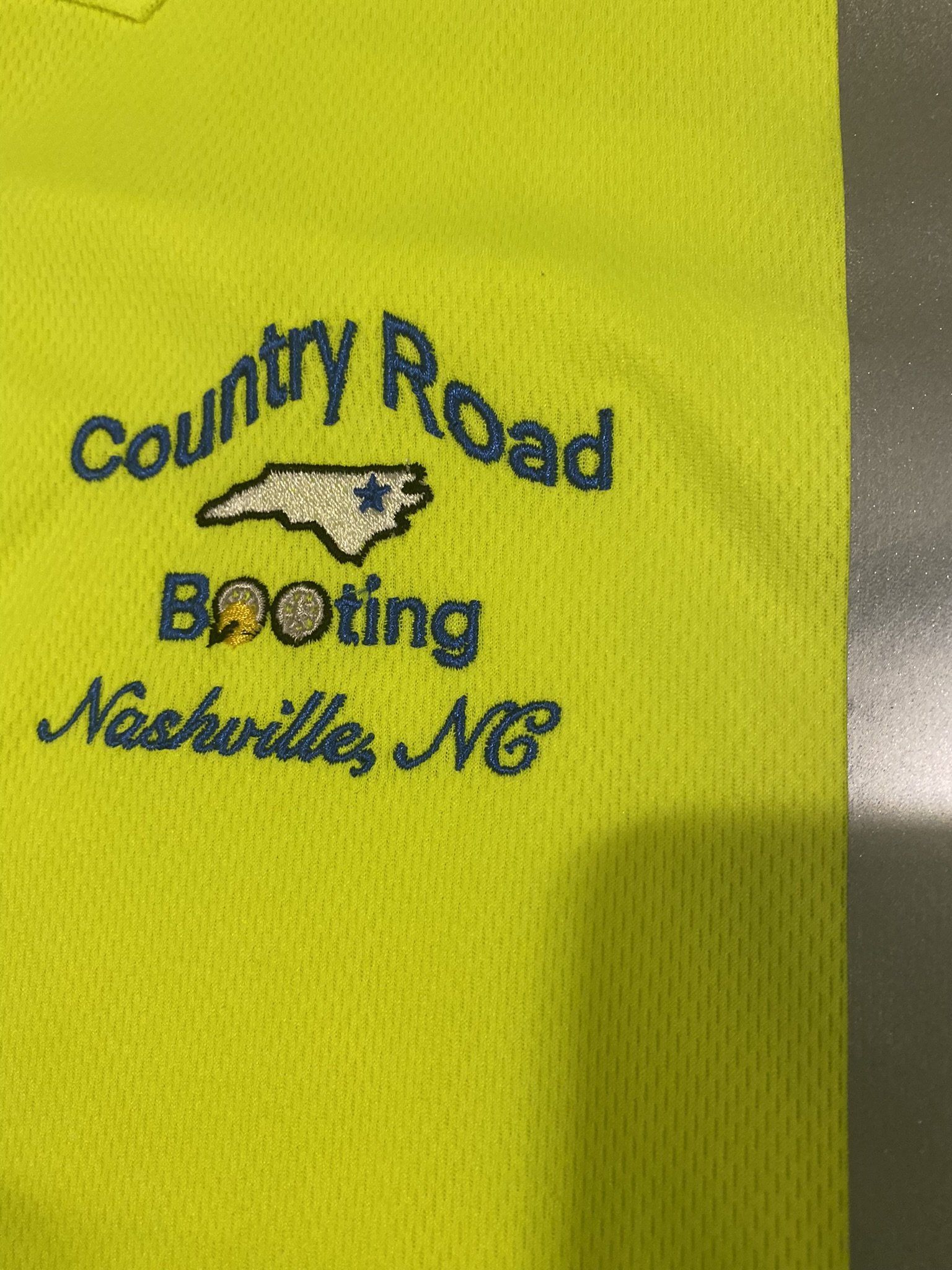 A yellow shirt with the words country road booting nashville nc embroidered on it