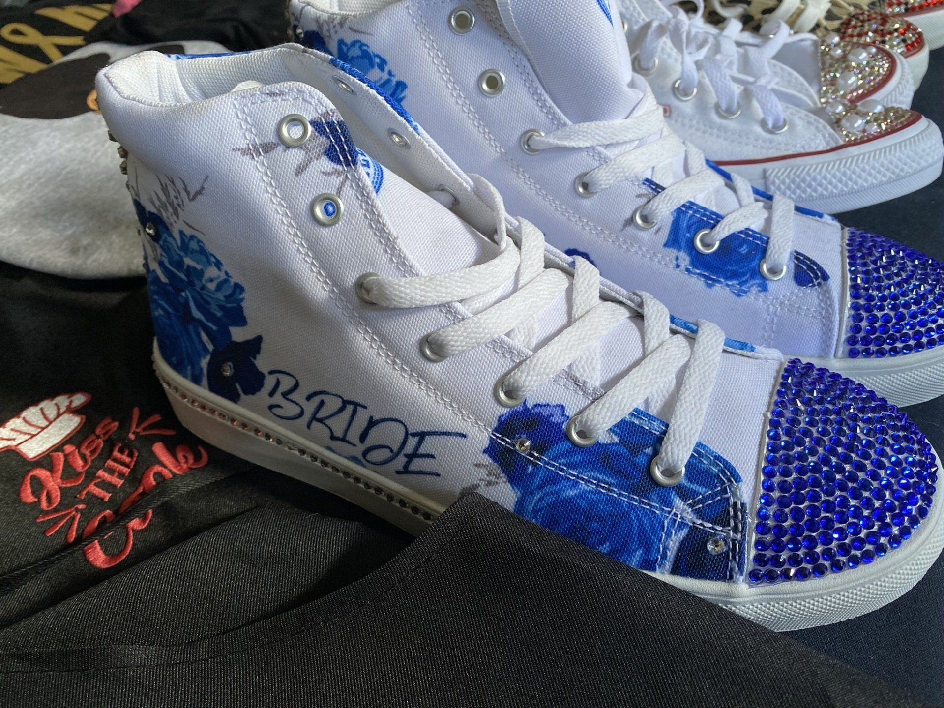 A pair of white high top sneakers with the word bride on them