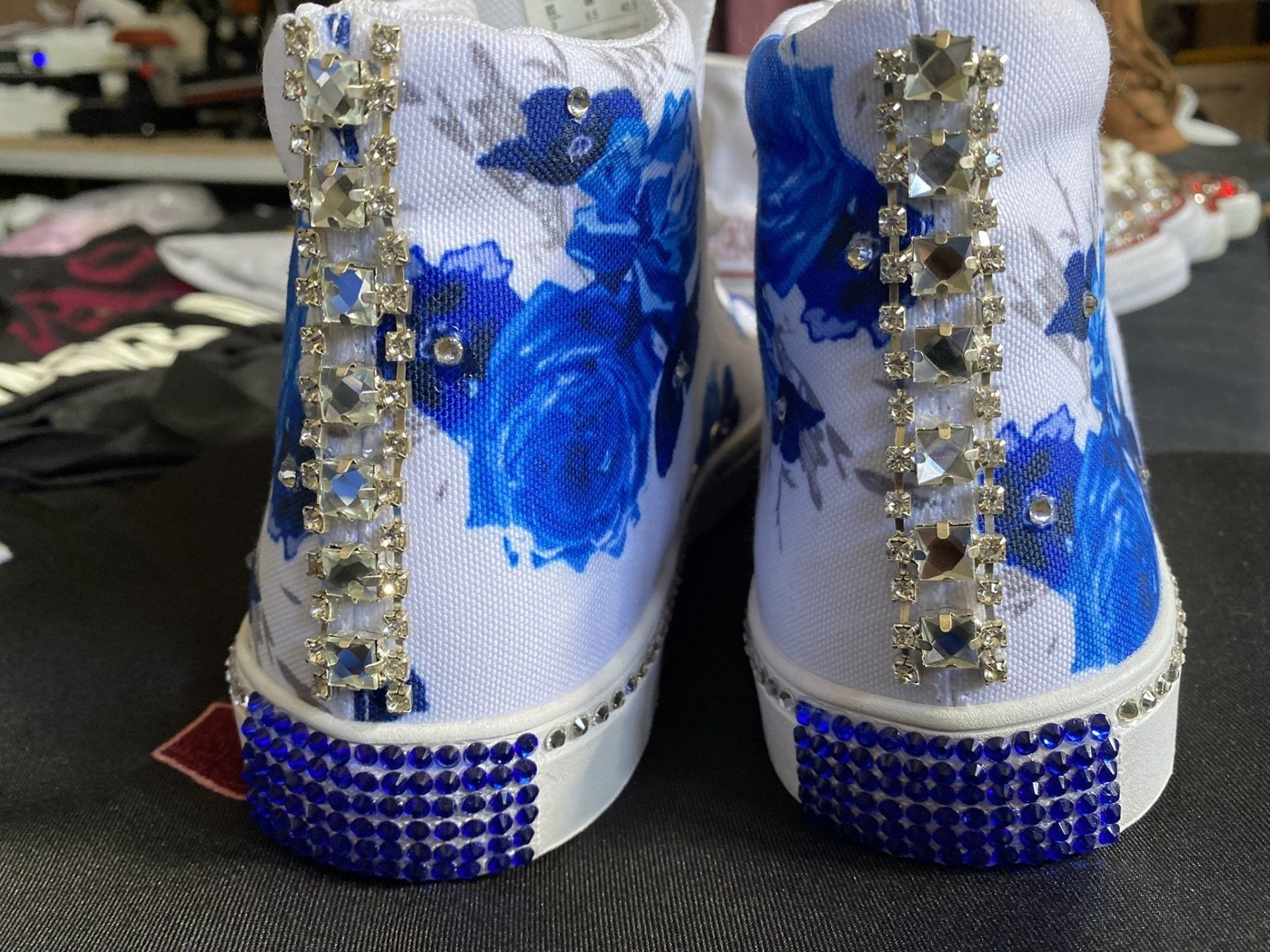 A pair of blue and white shoes with rhinestones on them