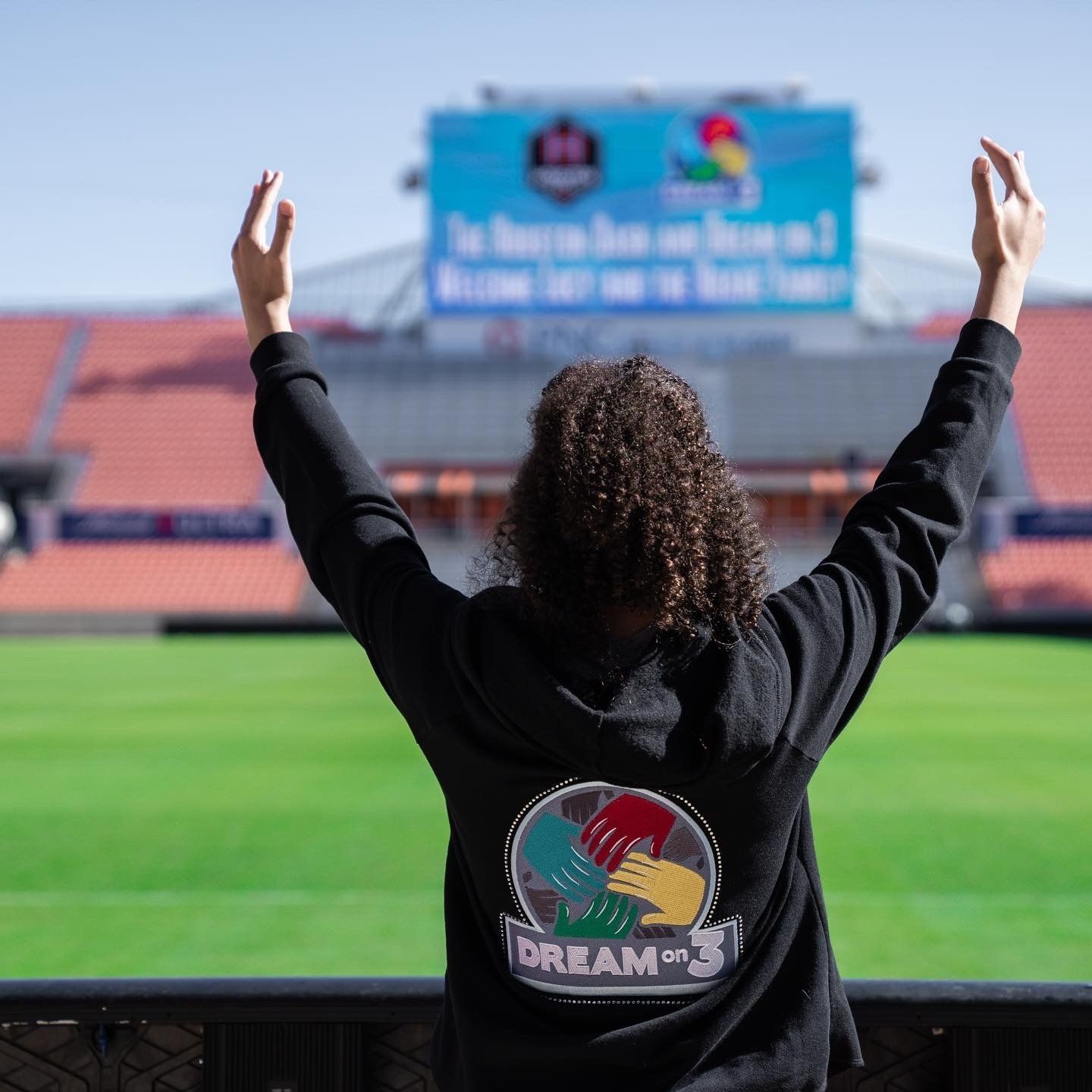 A woman wearing a black hoodie with the word dream on it