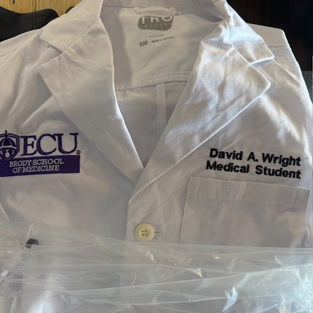 A white lab coat with david a wright medical student embroidered on it