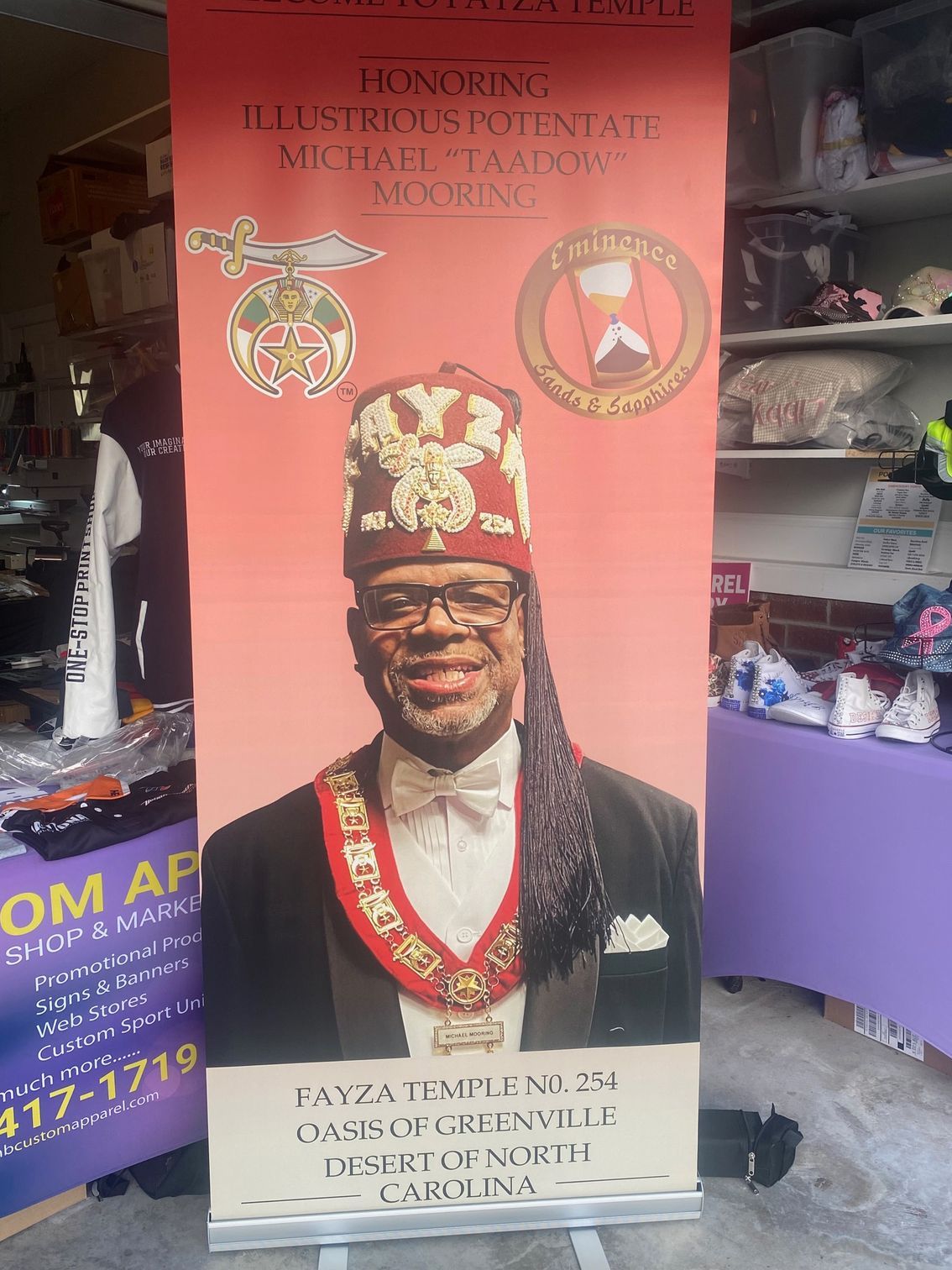 A man in a masonic uniform is standing in front of a purple table.