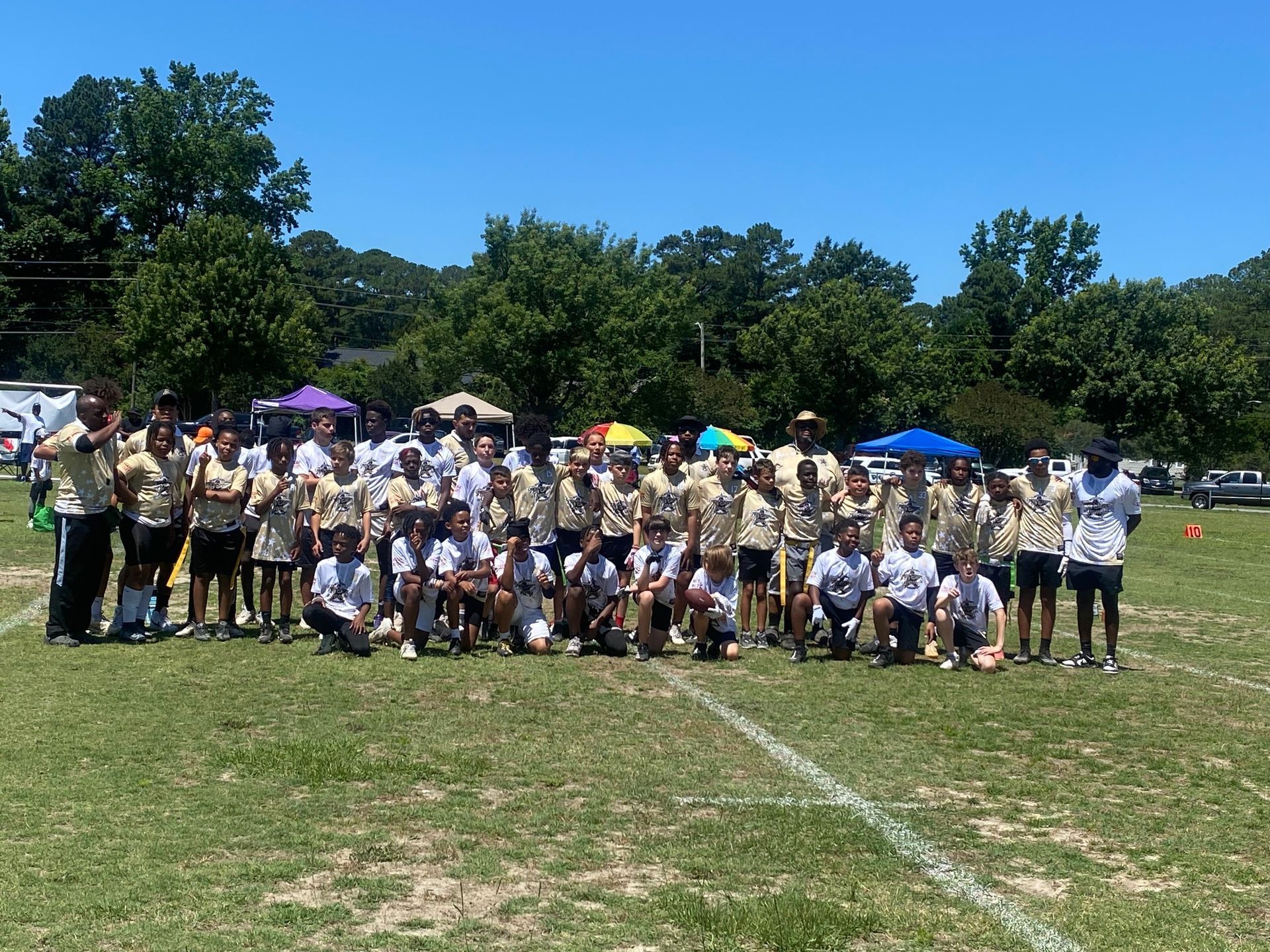 A group of people are posing for a picture on a field.
