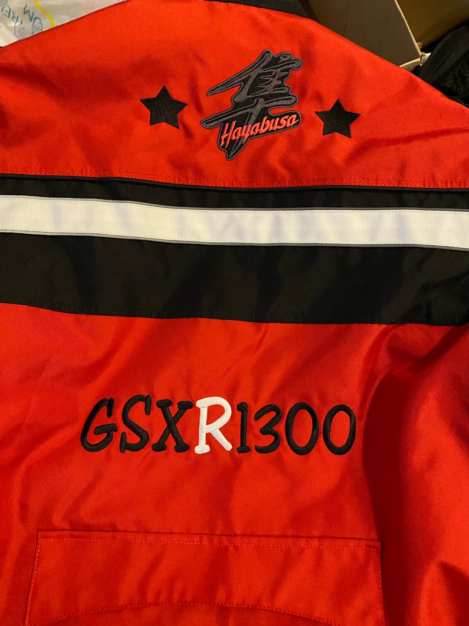 A red jacket with the word gsxr 1300 embroidered on it
