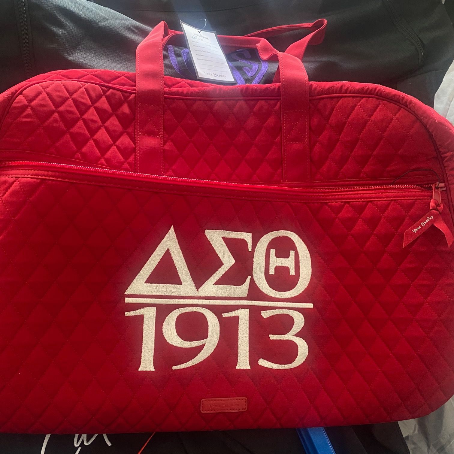 A red quilted bag with the year 1913 embroidered on it