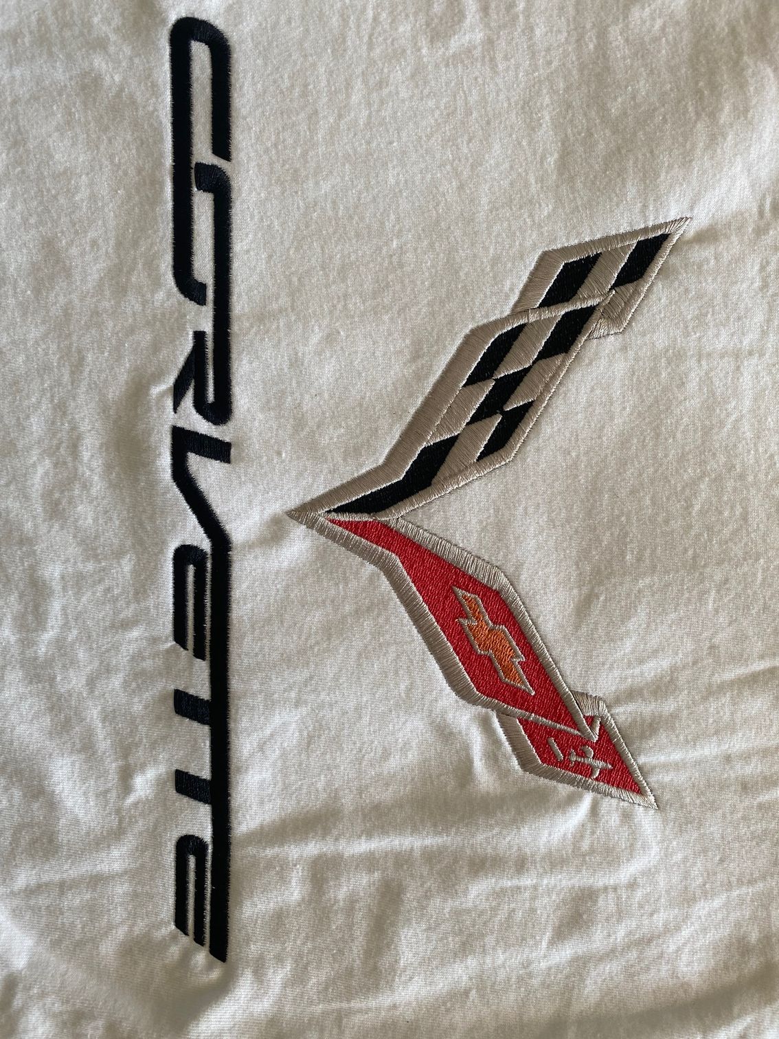 A corvette logo is embroidered on a white cloth