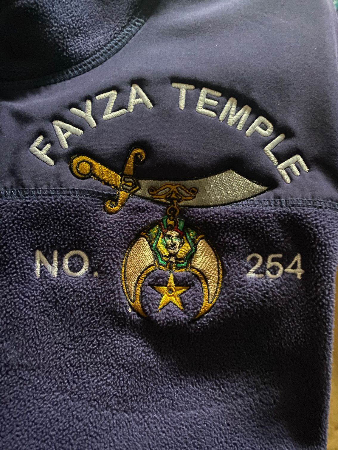A blue shirt with the words fayza temple embroidered on it