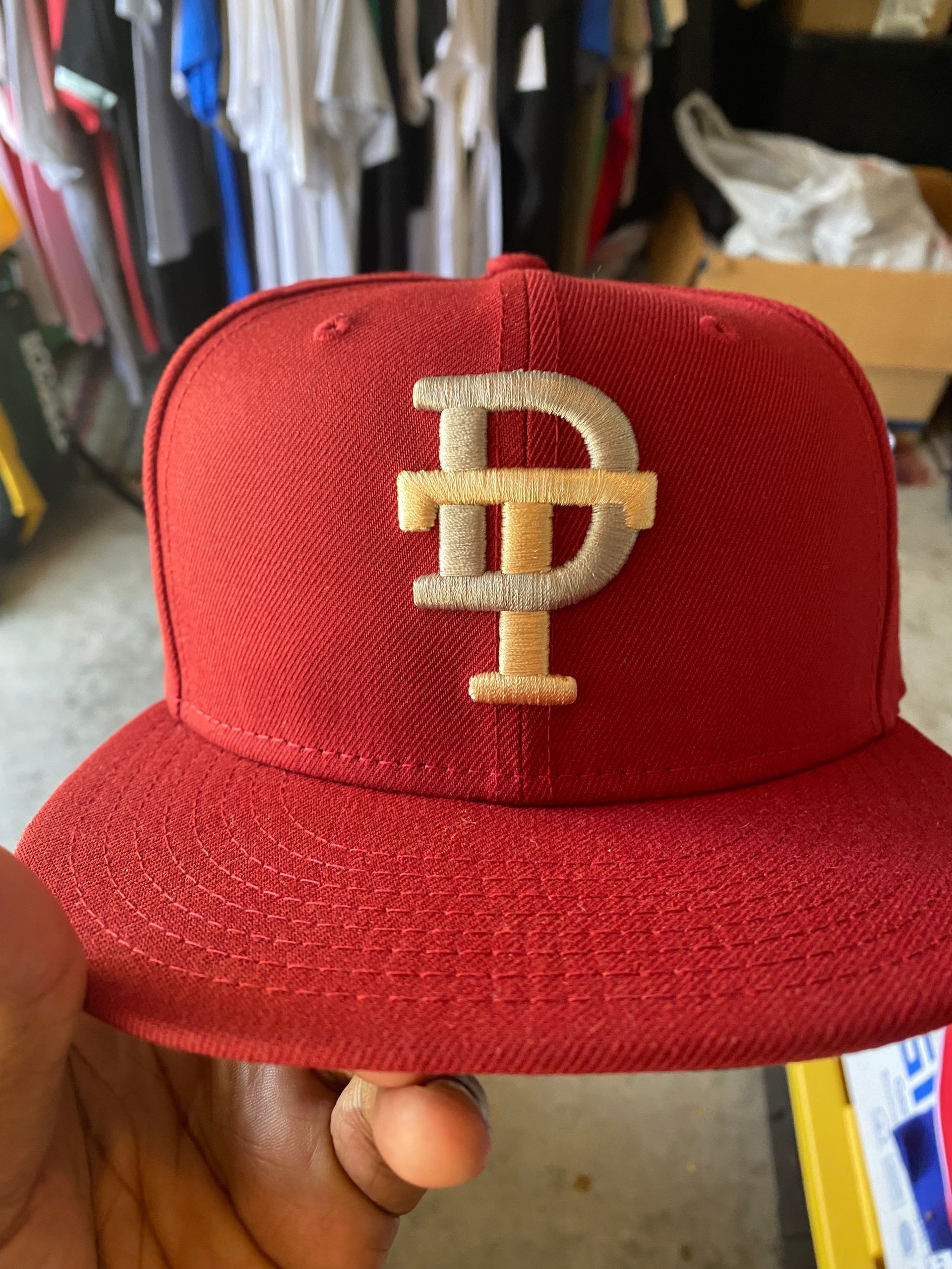 A person is holding a red hat with the letter p on it