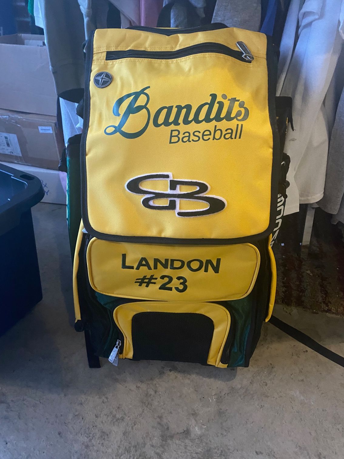 A yellow and green bandits baseball bag with landon # 23 on it