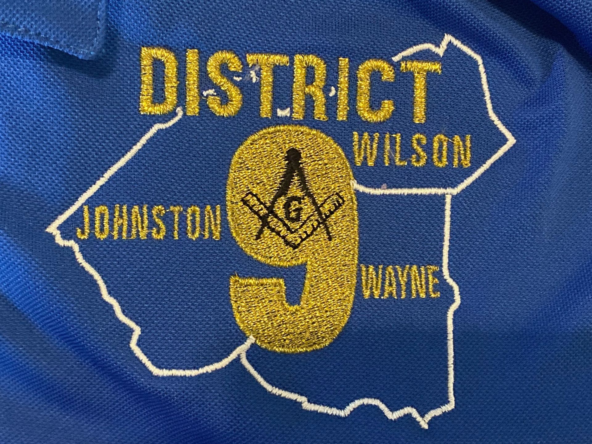 A blue shirt with district wilson embroidered on it