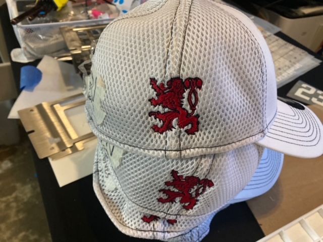 A white hat with a red lion embroidered on it