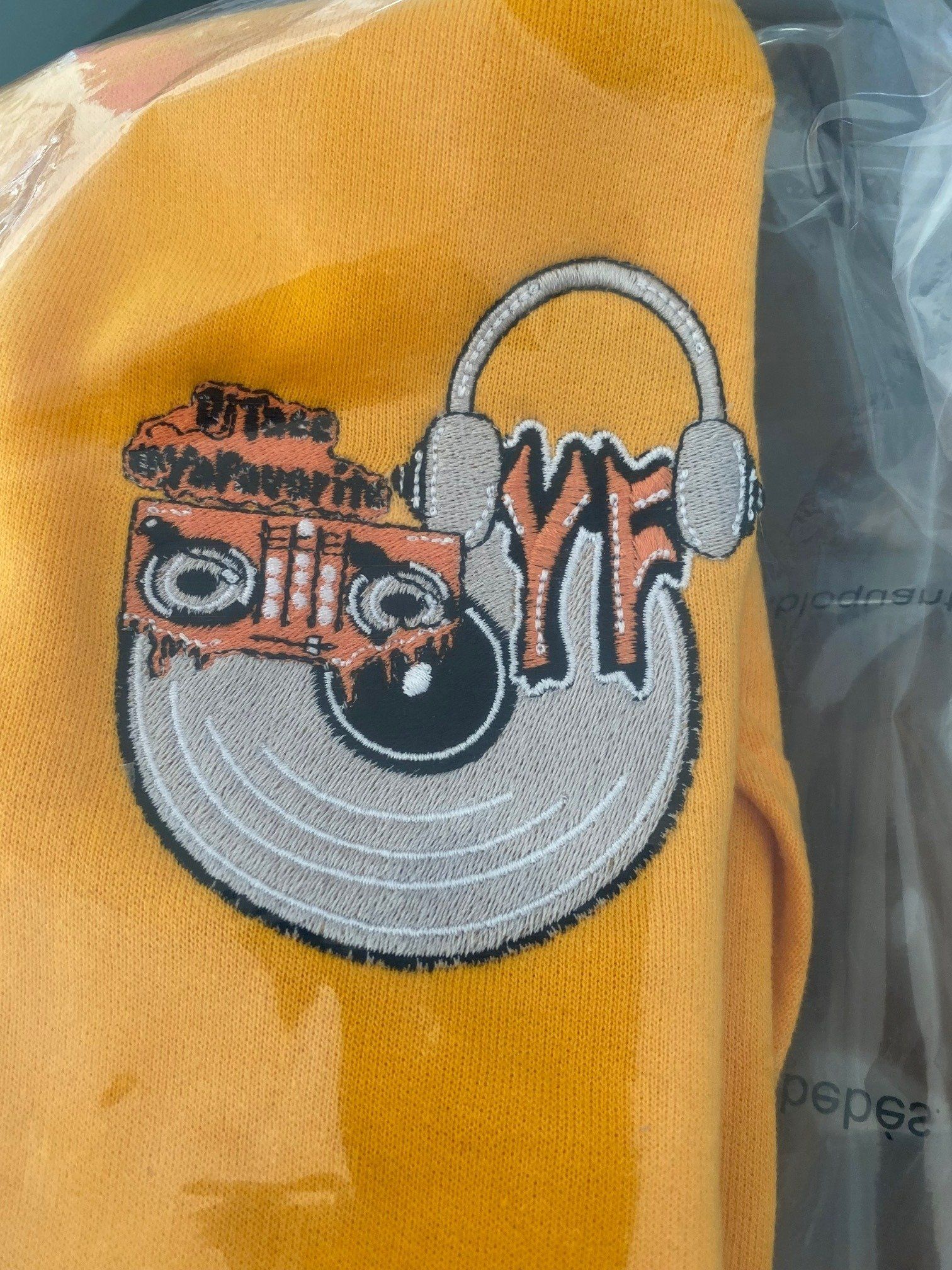 A close up of a yellow shirt with a logo on it