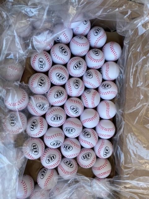 A box filled with a lot of baseballs with the word a & t on them