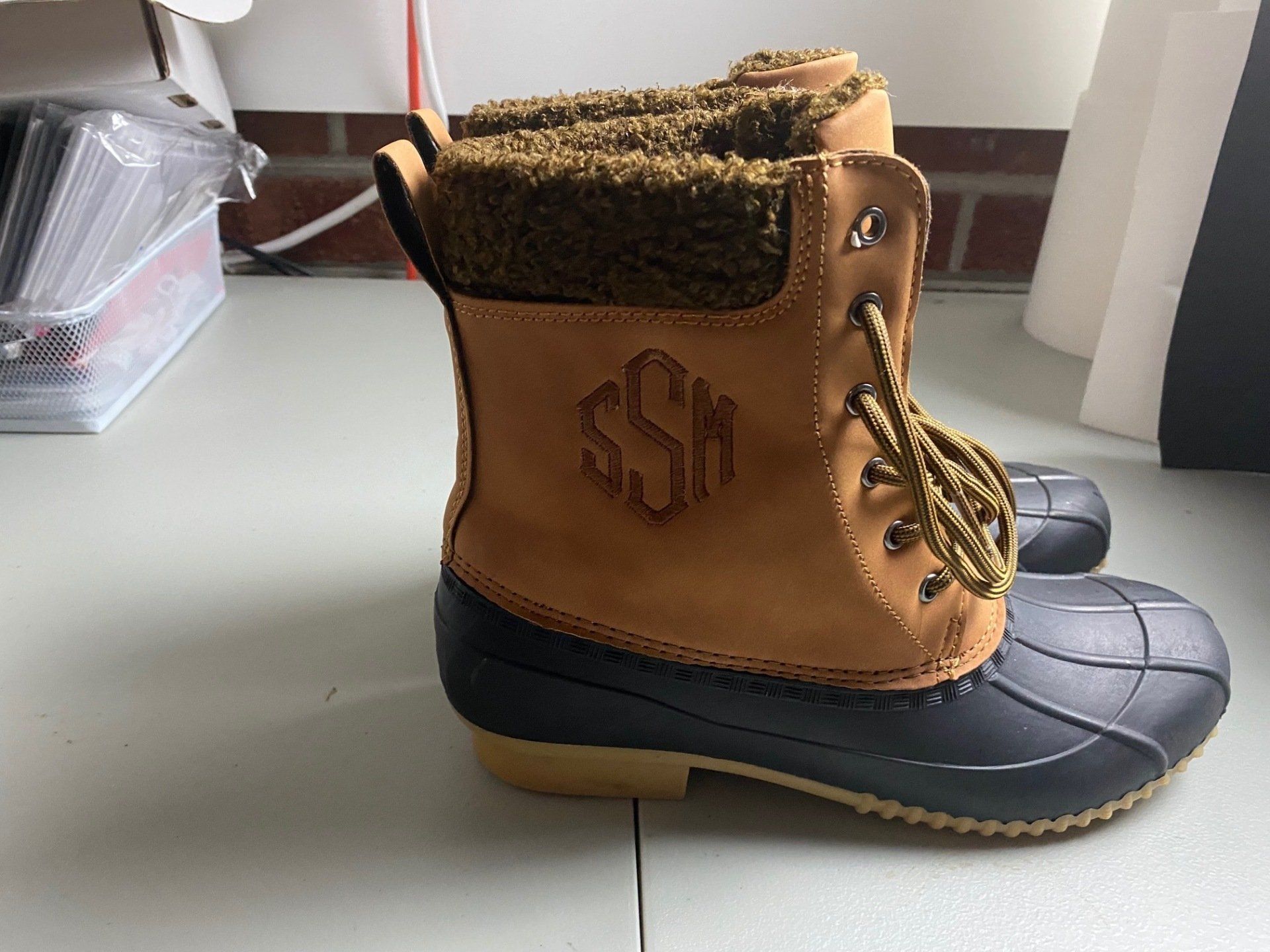 A pair of duck boots with a monogram on them