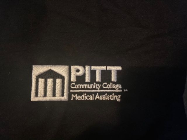 A black shirt with the pitt community college medical assisting logo on it