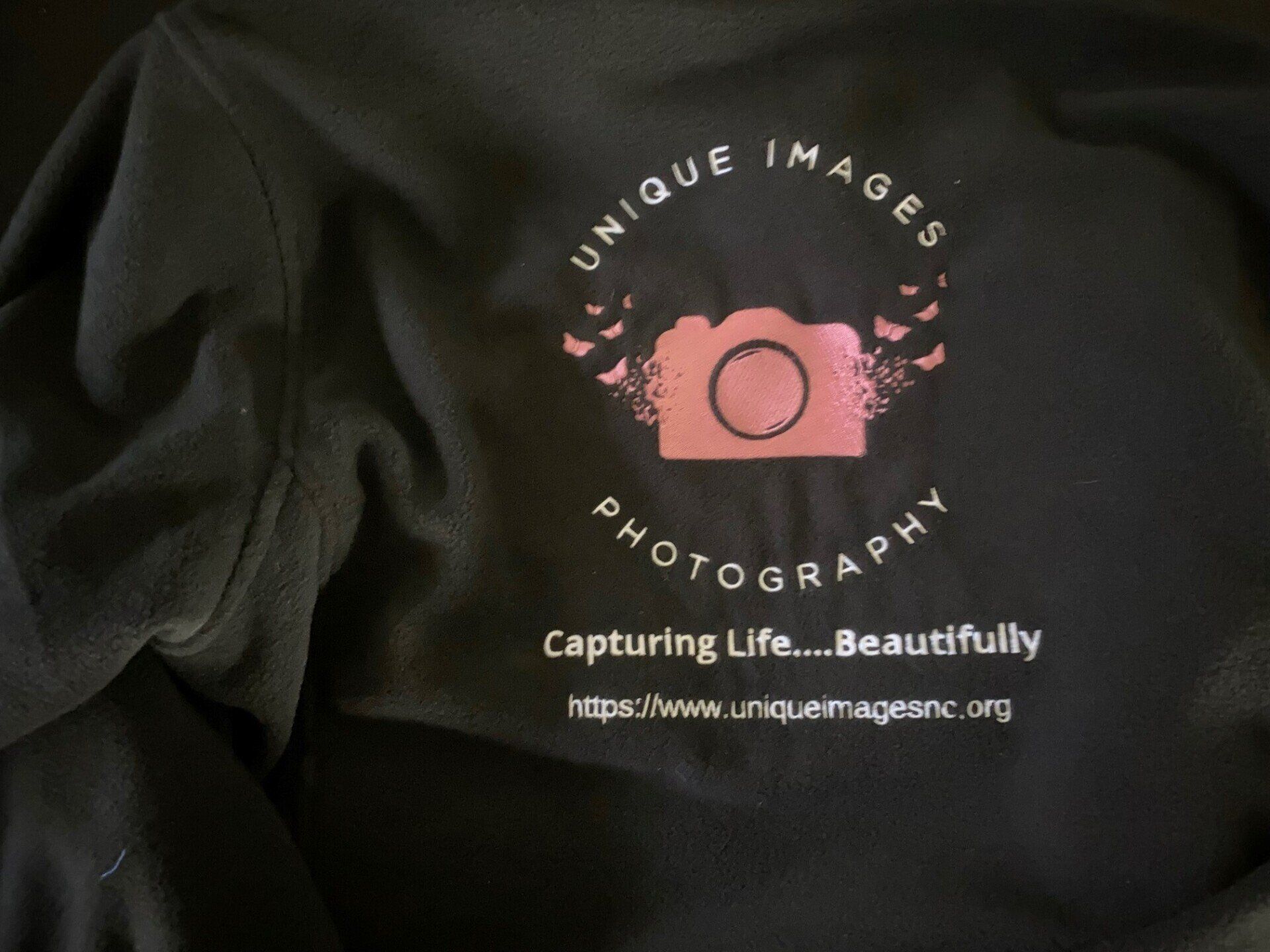 A black shirt that says unique images photography capturing life beautifully