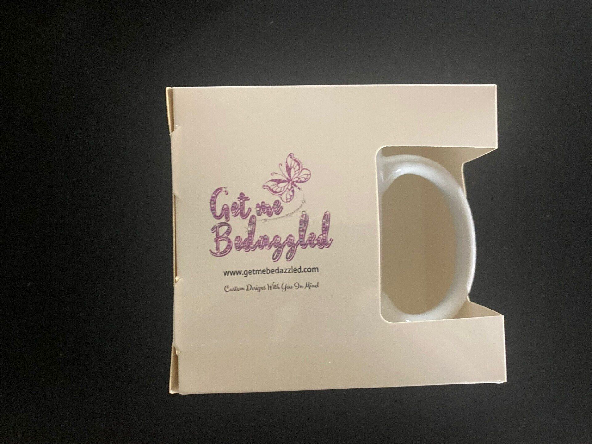 A white mug in a box that says get me believable
