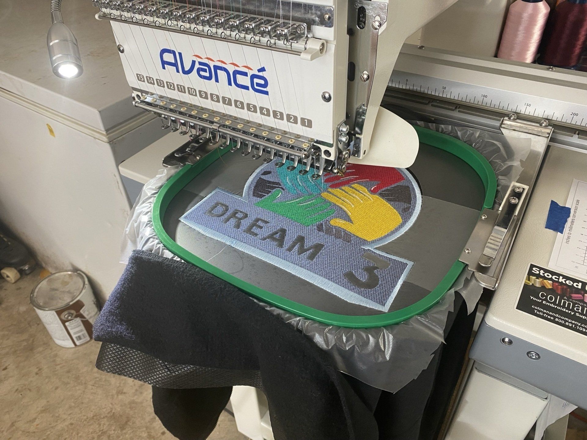 A machine is embroidery a logo on a piece of fabric.