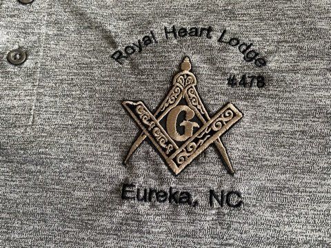 A close up of a masonic symbol on a shirt.