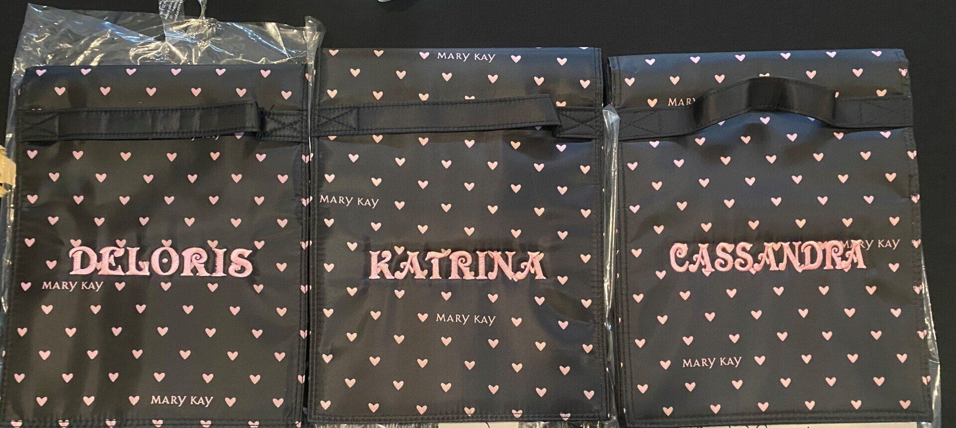 Three bags with the names katrina and cassandra on them