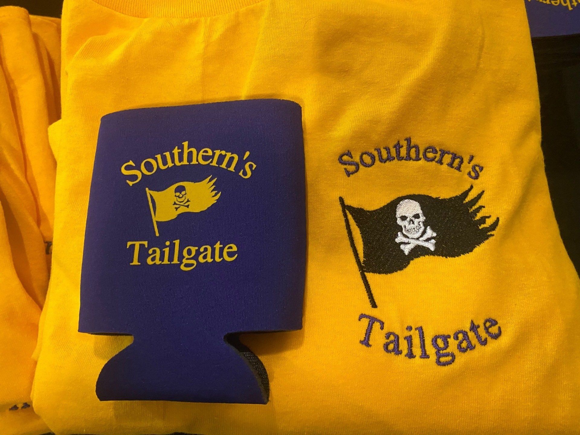 A yellow shirt that says southern 's tailgate next to a blue can holder