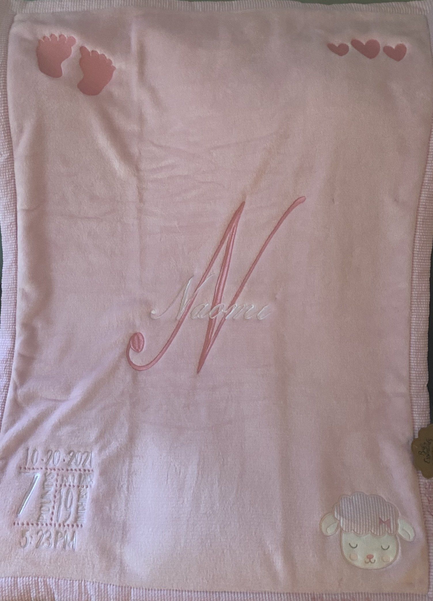 A pink baby blanket with the letter n on it