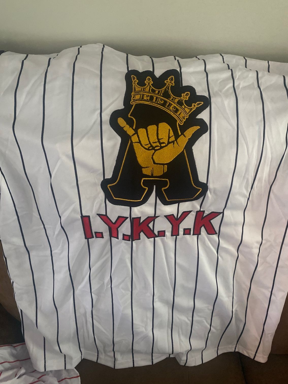 A ly.k.y.k shirt is laying on a couch