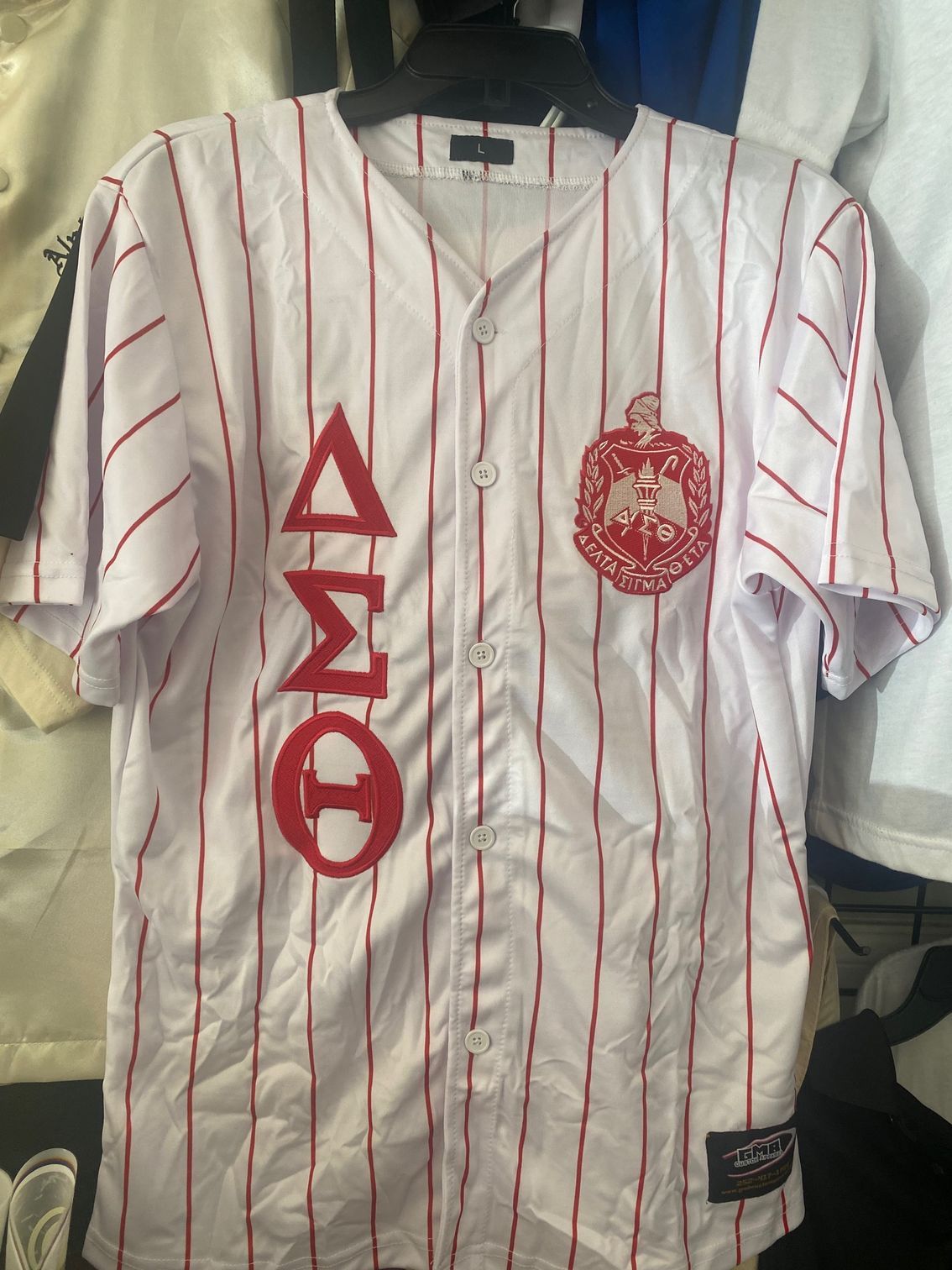A white baseball jersey with red stripes and the word omega on it